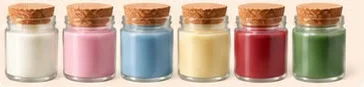 Seis velas pequenas com tampa de cortiça: branca, rosa, azul, amarela, vermelha e verde
