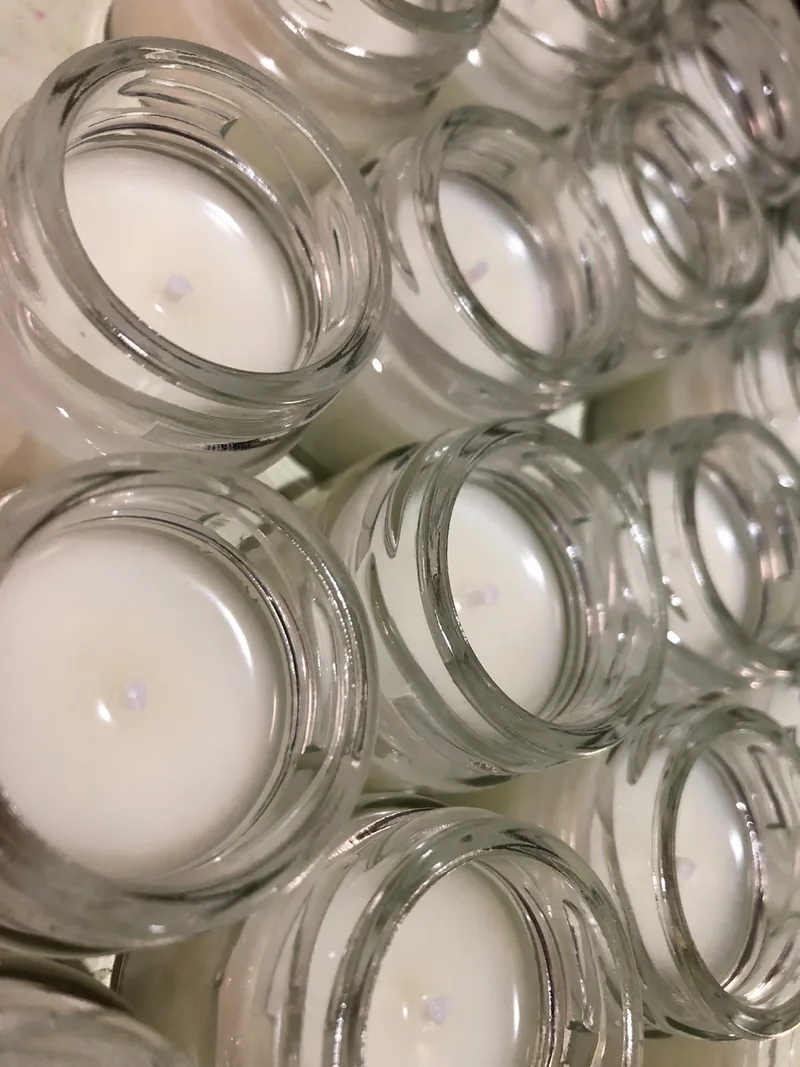 Velas brancas recém-feitas em potes de vidro, vistas de cima