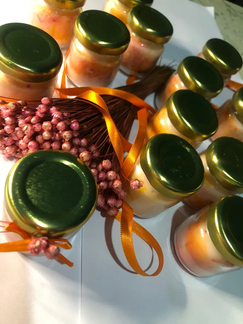 Velas marmorizadas com tampa dourada, fita laranja e flores secas
